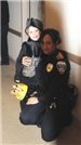Officer Smiles With Boy in Costume