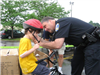 Officer Helps Young Child Latch Helmet