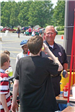 Officer Stands With Children Drinking Water