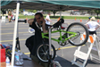 Resident Works on Green Bike Under Tent