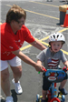 Volunteer Helps Child on Bike
