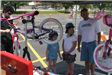 Young Girls Watch as Their Bike Gets Checked Over