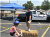 Volunteer Leans on Hay Bale