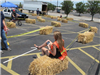 Volunteer Sits on Hay Bale