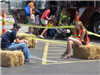Volunteers Sit on Bales Waiting for Riders