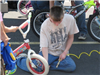 Young Volunteer Airs Up a Tire