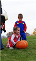 Girl in Cheerleading Costume Rolls a Pumpkin