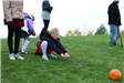 Girl Watches as Pumpkin Rolls Down Hill