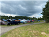 A landscape picture of all the cars participating in the Car Show, cars are in the distance 
