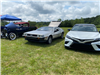 3 Cars, the Car on the Left is a vintage navy car, the middle a DeLorean and the last a Camry