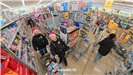 2 Officers take a picture from a high angle in a shopping aisle
