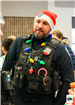 An officer is pictured wearing his utility vest, around his neck is a christmas light necklace