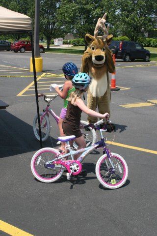 Young Children on Bike Watch Moose Mascot