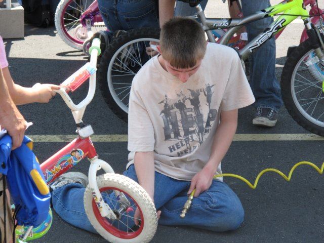 Young Volunteer Airs Up a Tire