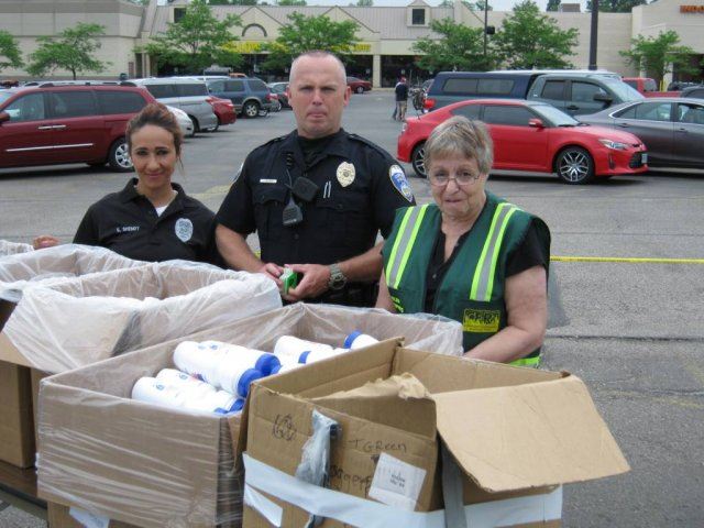 Volunteers Smile With Water Bottle Boxes