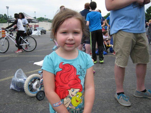 Young Girl Smiles With Her Bike