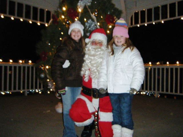 Santa Kneels Down to Smile with Young Children