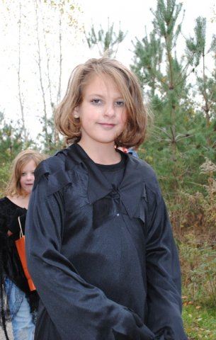 Young Girl Smiles in Black Costume
