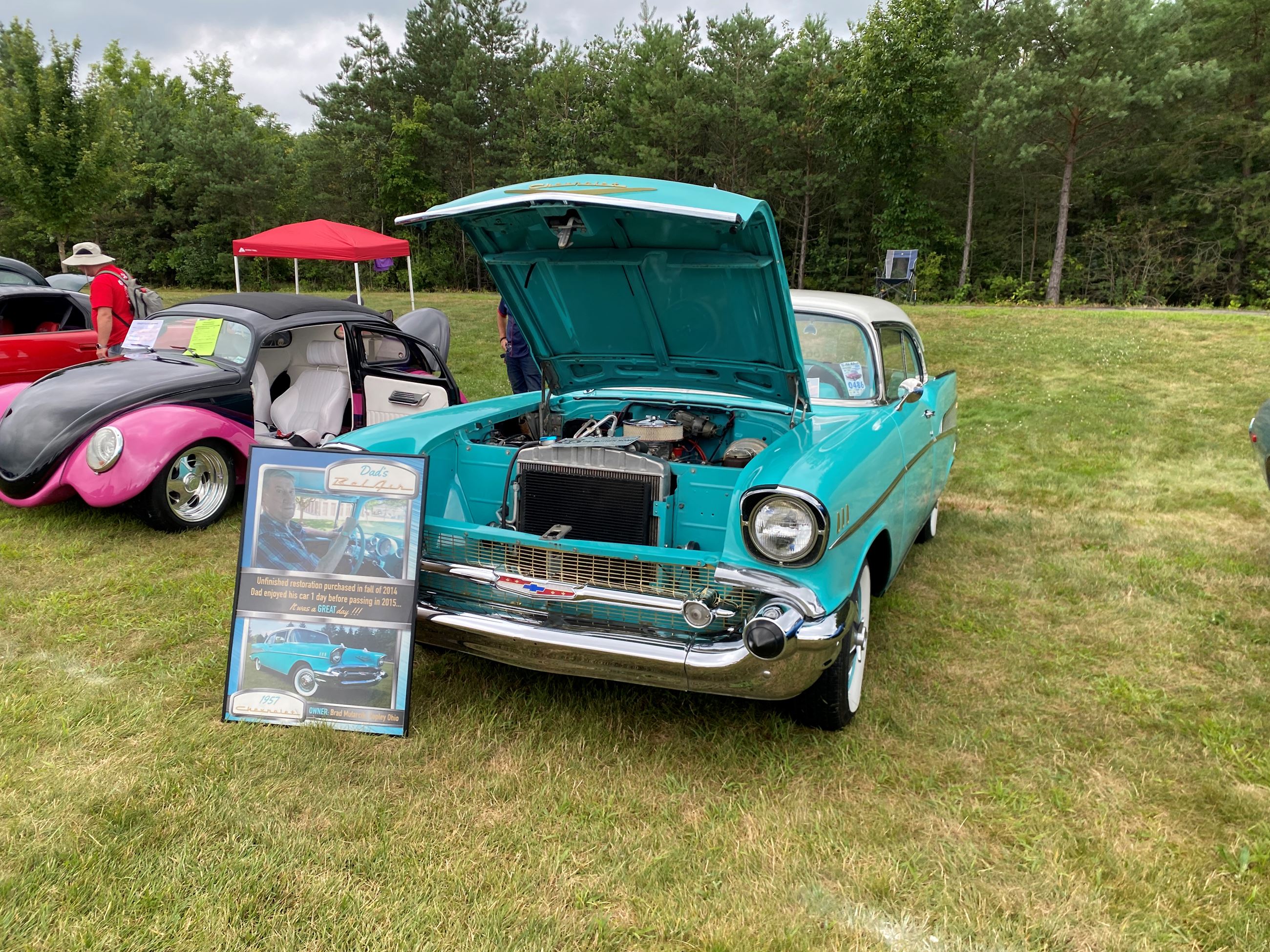 1957 Teal Chevrolet Bel Air With It's Hood Open and a Display listing info about the car at Car Show 2025