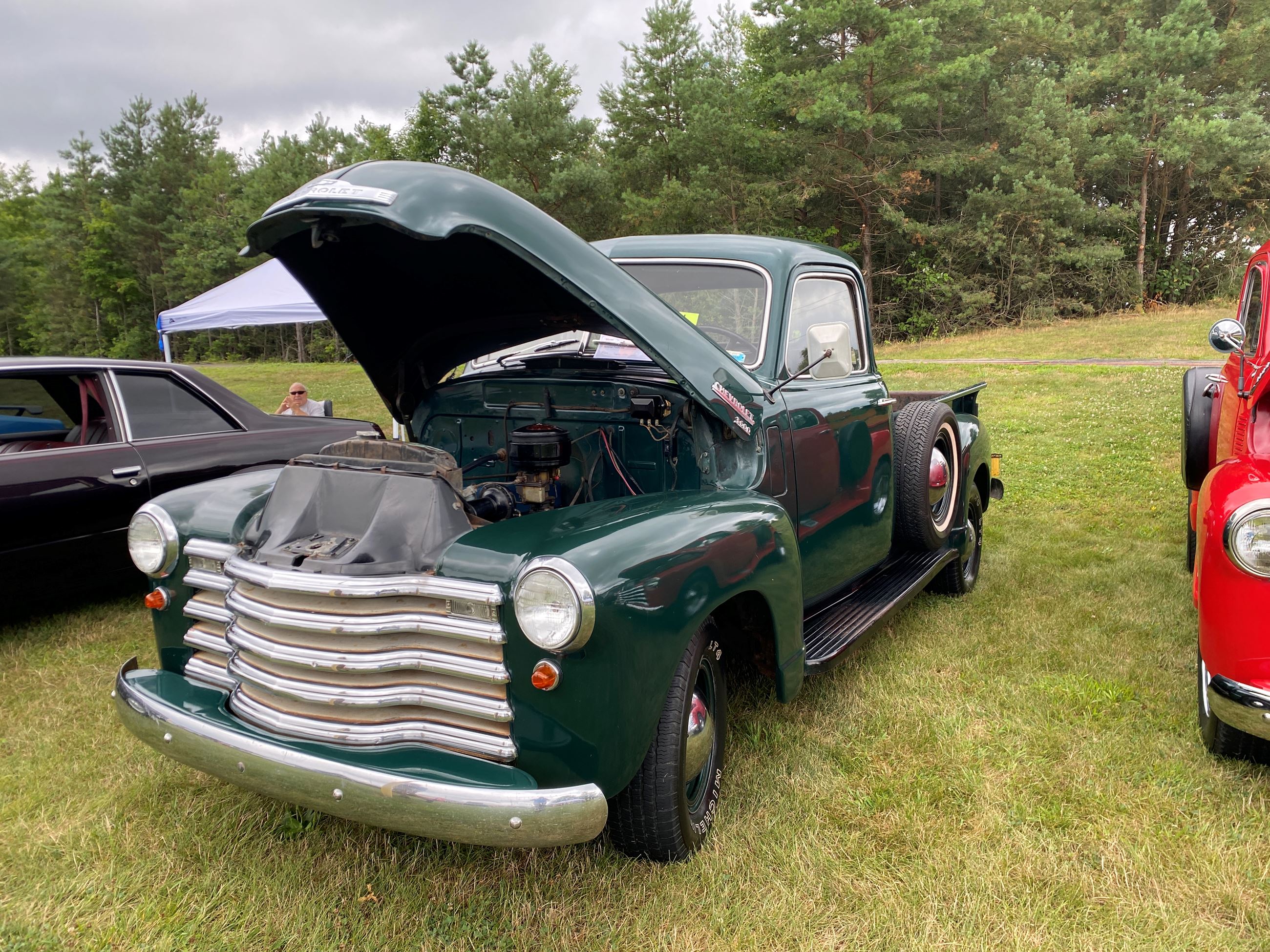 A Dark Green Truck with the Hood Up on Display