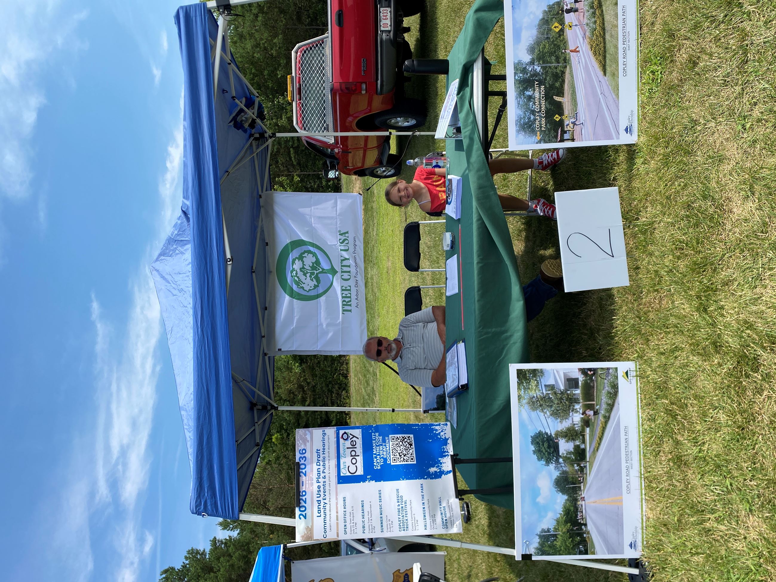 Code Enforcement Officer Jeff Newman and family member Under Blue Copley Tent Displaying the Land Use Plan Draft and Infrastructure Development in the Township