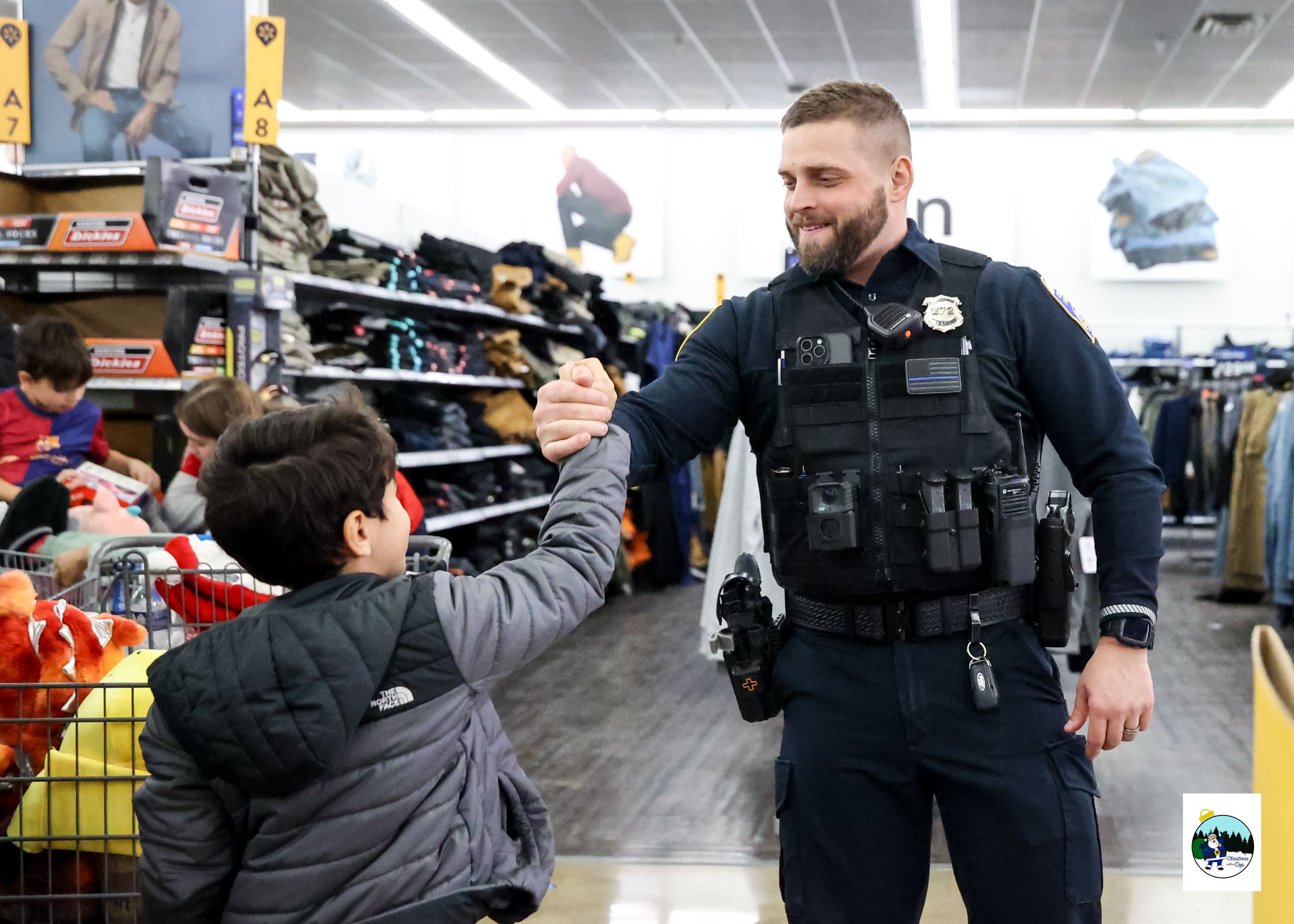 An officer and a child are sharing a hand shake