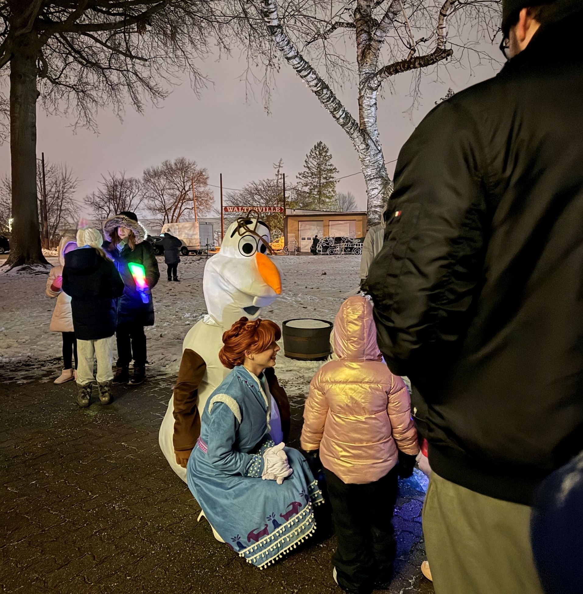 Olaf and Anna crouch and pose for photos with children outside