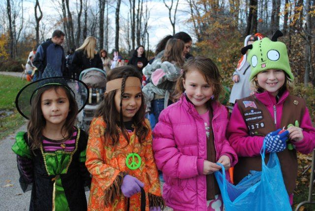 Young Children Wear Costumes as They Go Towards Candy