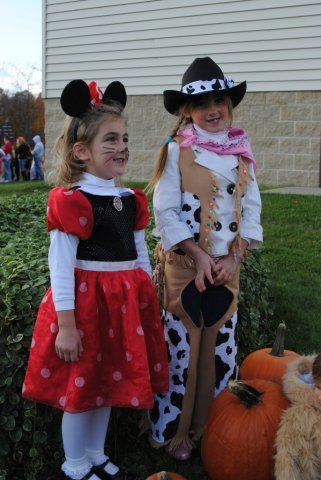 Young Girls Smile for Camera Near Pumpkins